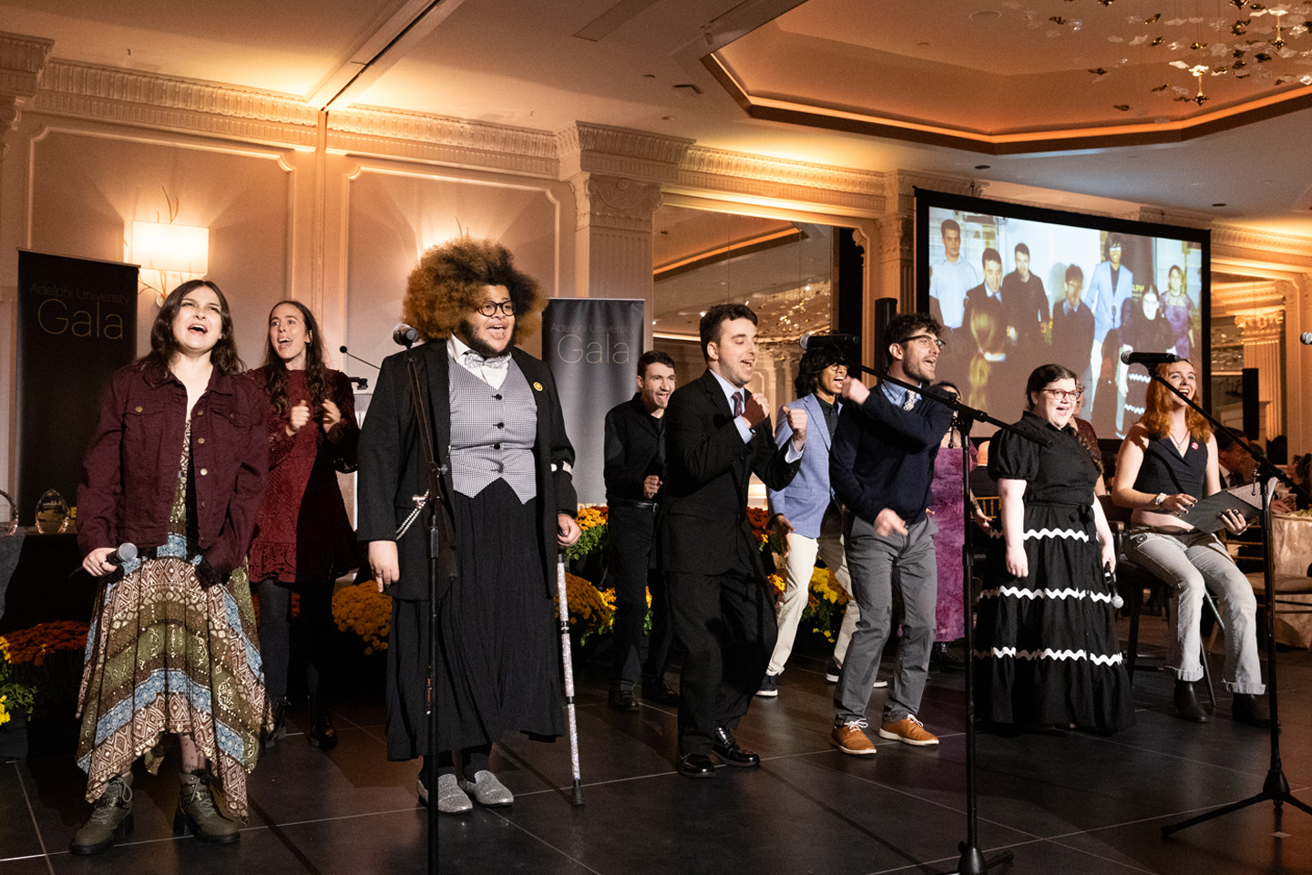 A singing group in formal wear sings from the Gala stage.
