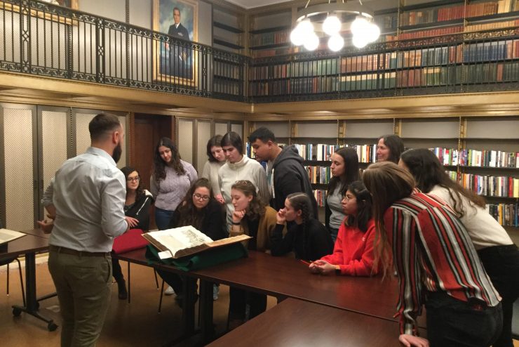 Honors College students surrounding a manuscript with their instructor
