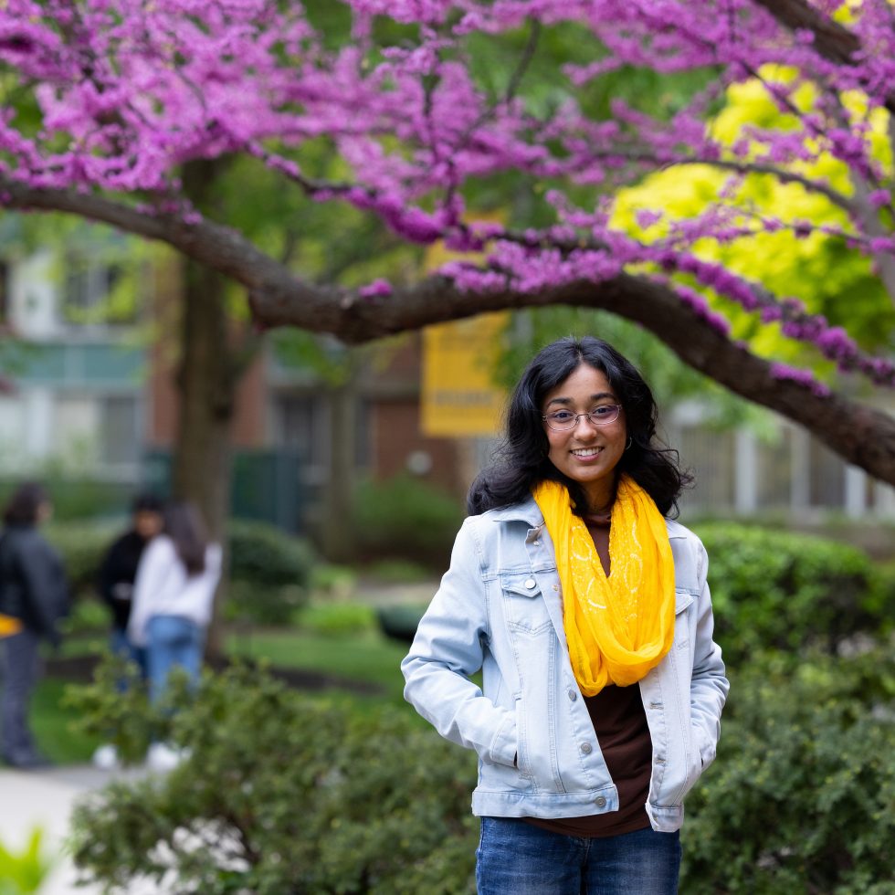 An Adelphi University student looking at the camera on campus.
