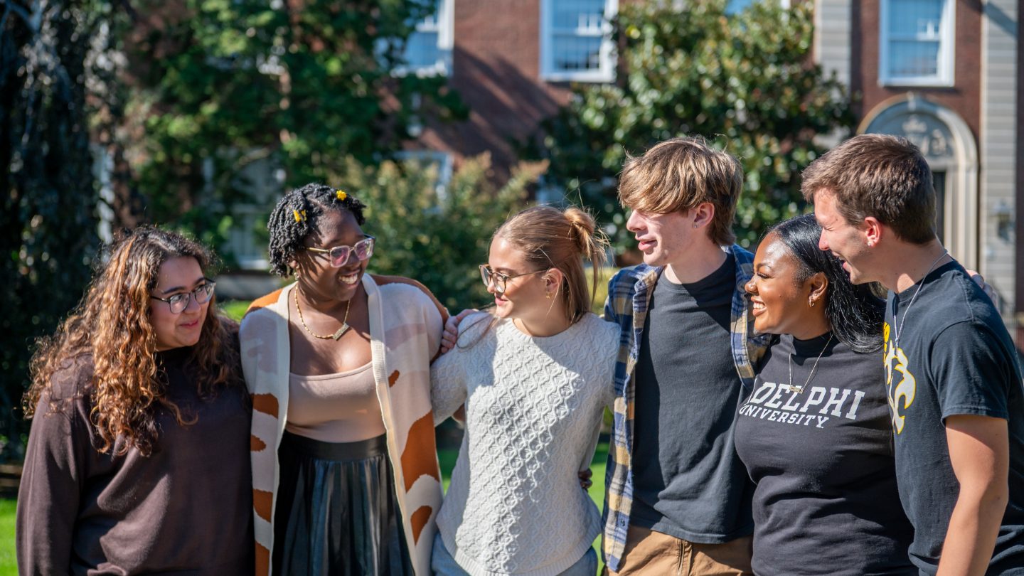 Adelphi students linked arms together on campus