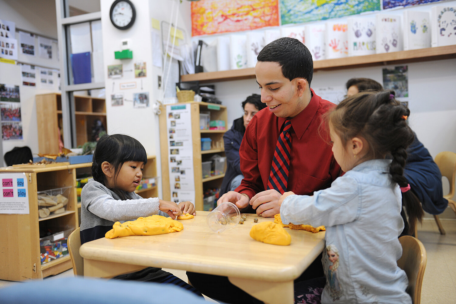 Student teacher with two yound children in the early learning center