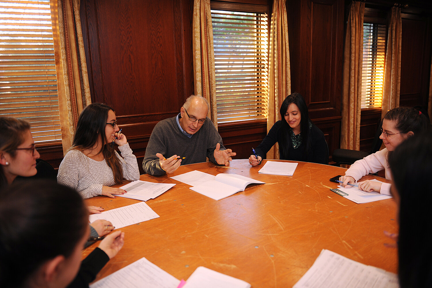 Four students with a faculty member sitting around a table.