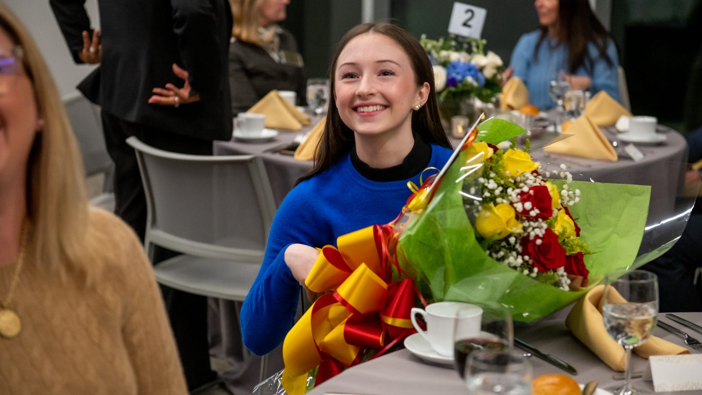 A Prize for Leadership recipient holds roses in excitement.