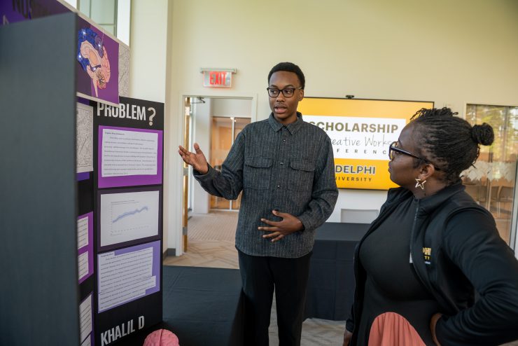 A high school junior presents original research to Adelphi University faculty at the Scholarship and Creative Works Conference, showcasing creativity, curiosity and academic achievement.