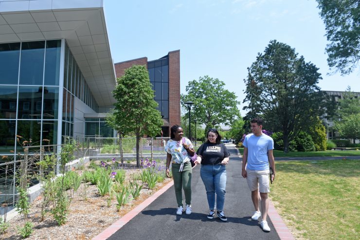 Students walking by the UC in the warm weather.