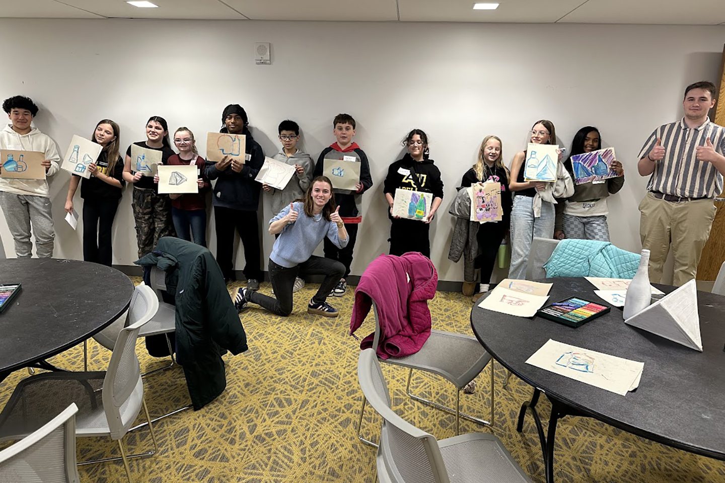 Children lined up displaying their art pieces