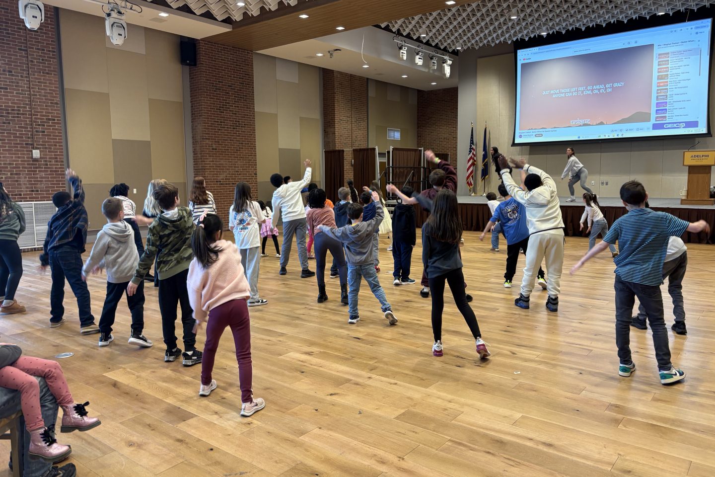A lively group of kids dance together, filling the room with energy, laughter and music.