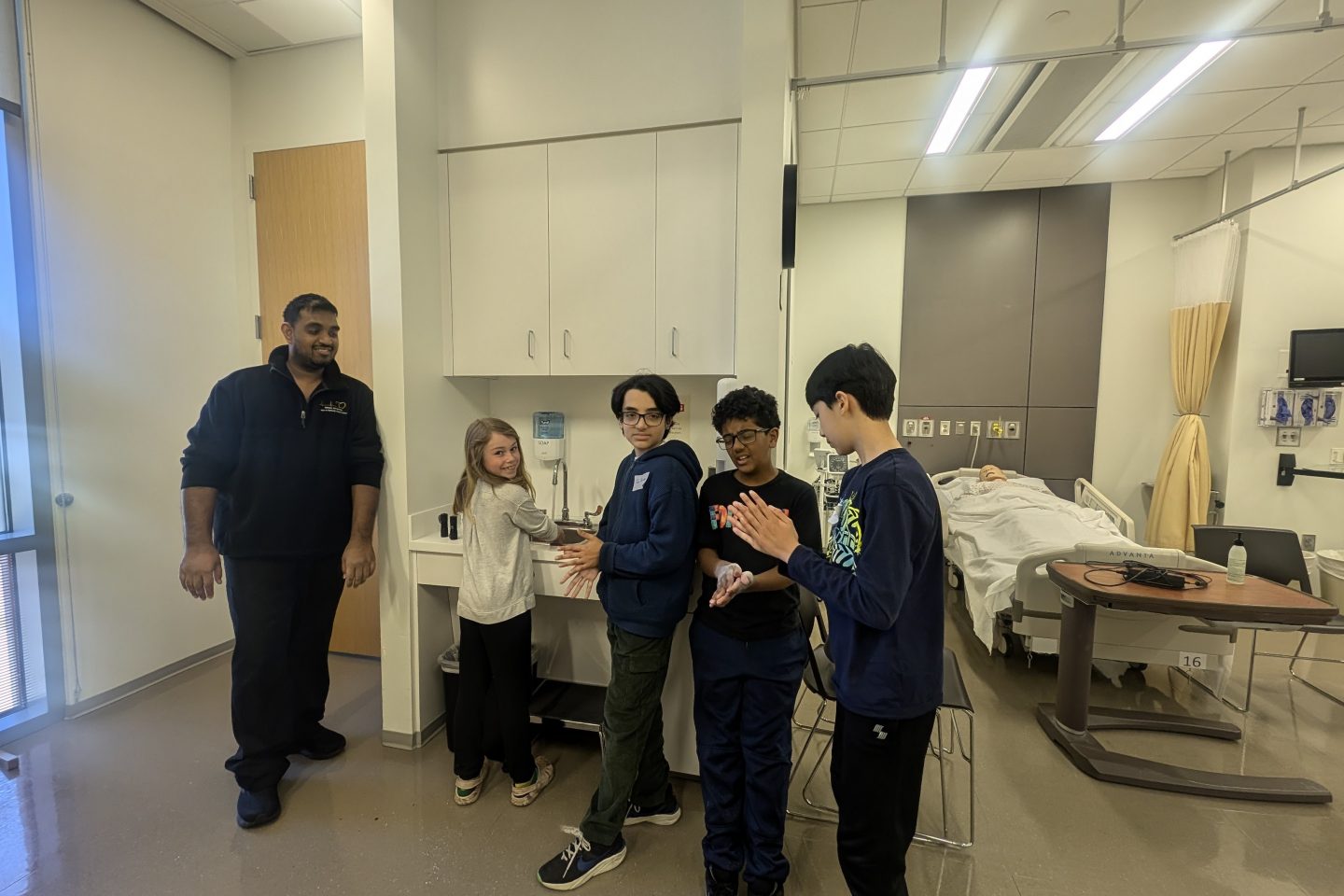 four children washing their hands in the sim lab