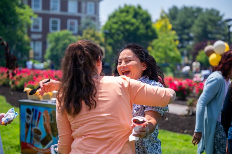 Two Adelphi employees embrace at the annual summer BBQ