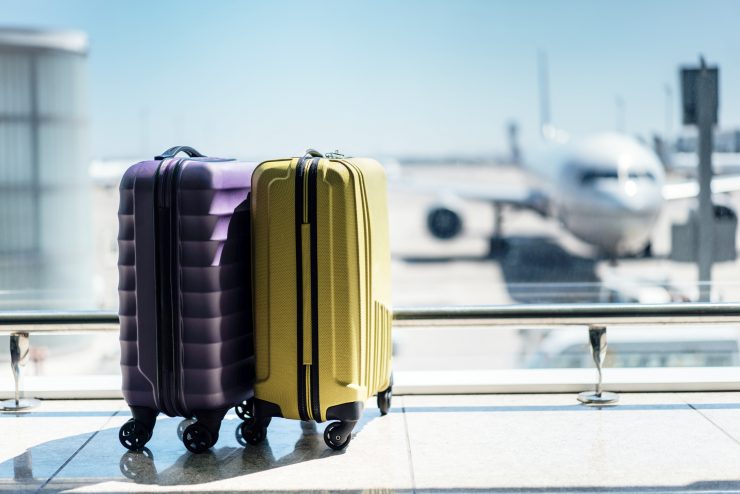 Suitcases in airport departure lounge, airplane in