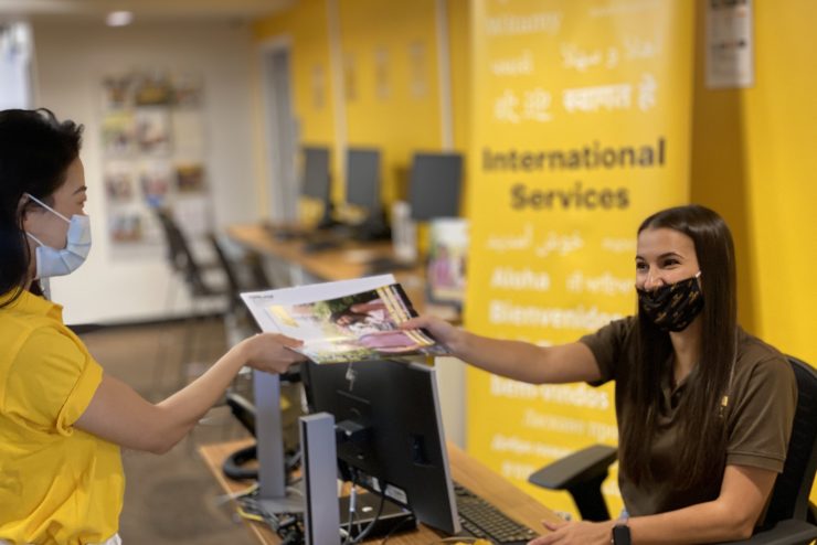 A student working at Adelphi handing someone a brochure