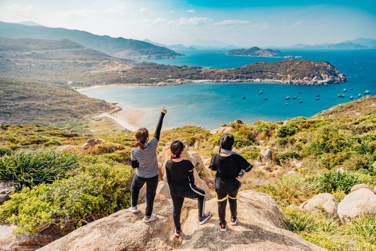 Students traveling looking over a cliff to a beautiful blue ocean