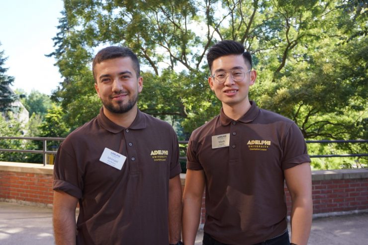 Two Adelphi students wearing uniforms on campus.