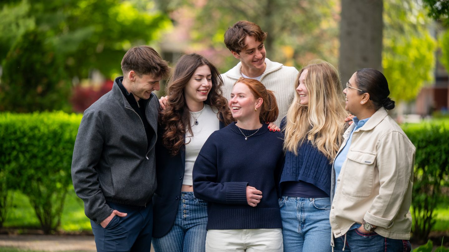 A group of Adelphi students talking on campus.