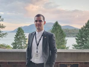 Mikautadze, wearing a gray suit with a lapel button of the U.S. and Georgia flags, stands on the Military Academy campus on a beautiful late afternoon with the Hudson River and Storm King Mountain in the background.