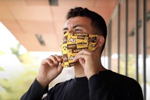 Adelphi student wearing a mask with the Adelphi logo on the front