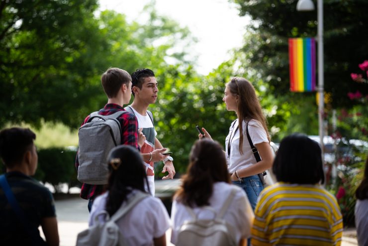 Welcome weekend at Adelphi. Students standing near pride banner near the UC.