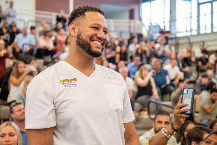 A joyful Adelphi nursing student in a crowd