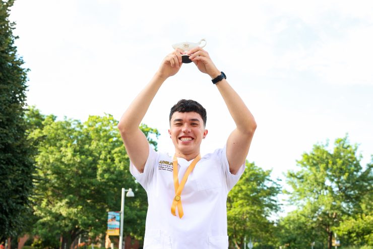 A nursing student hold up his award after the pinning ceremony