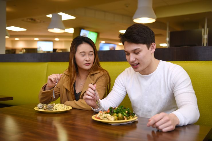 Students eating at a table at Post Hall