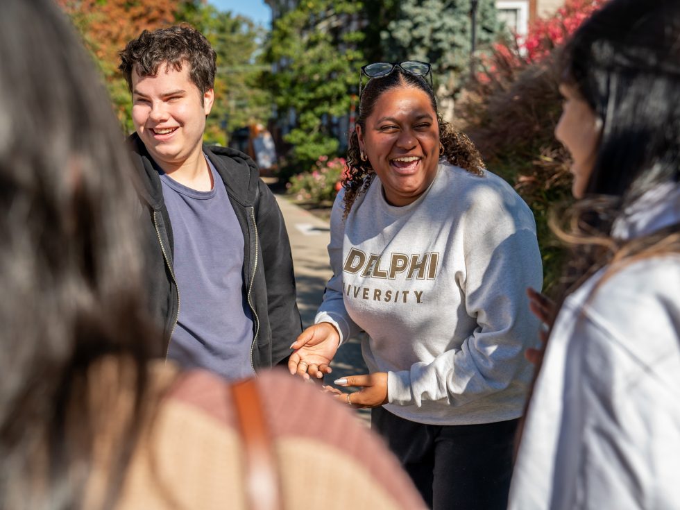 Adelphi student laughs with friends on campus.