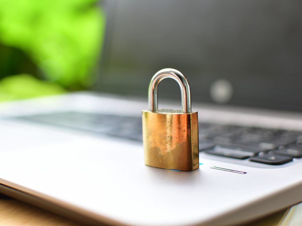A metal lock sits on a laptop: concept of data privacy