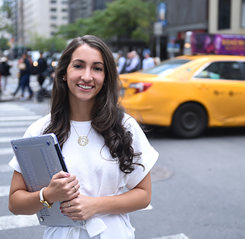 Adelphi student holding laptop in NYC