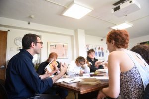 A group of students sitting at a table talking.