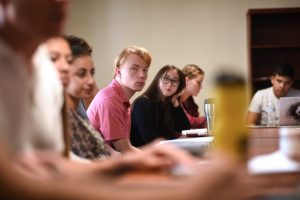 Students sitting listening to a faculty member.