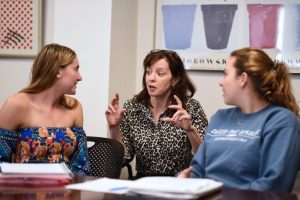 A faculty member speaking with two srudents