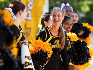 Adelphi cheerleaders line up with their pompoms and megaphones on a beautiful fall day.
