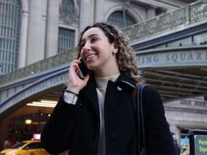 A young woman talking on her cellphone walks past Grand Central Station.