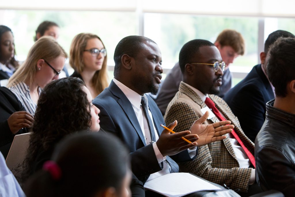 Professional training at Adelphi University - View of a man in a suit asking a question in a session