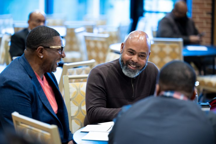 Professionals smiling at a table at Adelphi University