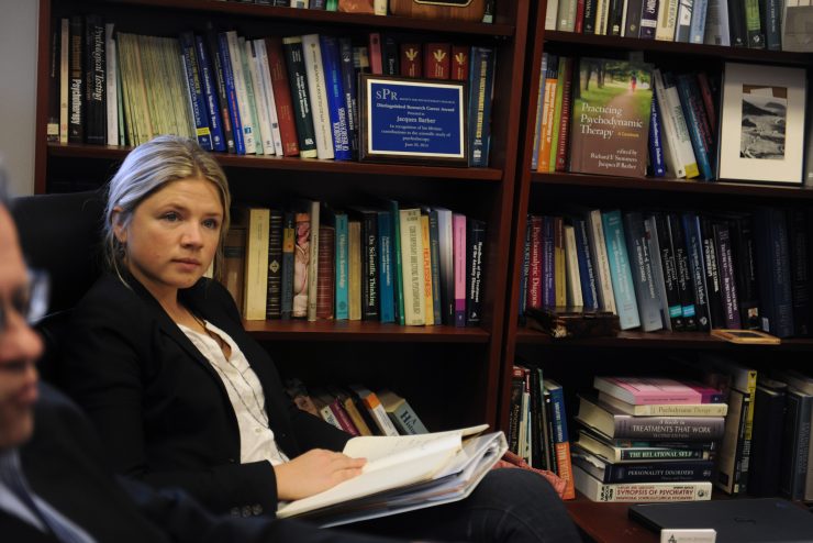 postgraduate psychotherapy - woman studying in a room full of books at Adelphi's School of Psychology