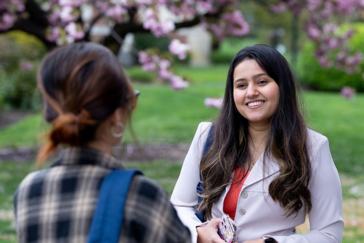 smiling student mentors outside with cherry blossoms