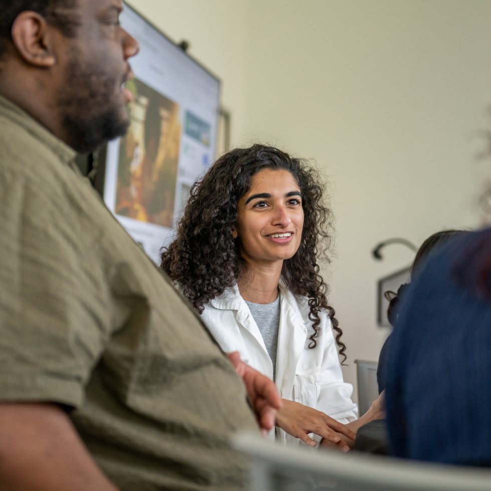 A Derner School of Psychology student speaks with classmates during a mentoring session at Adelphi University