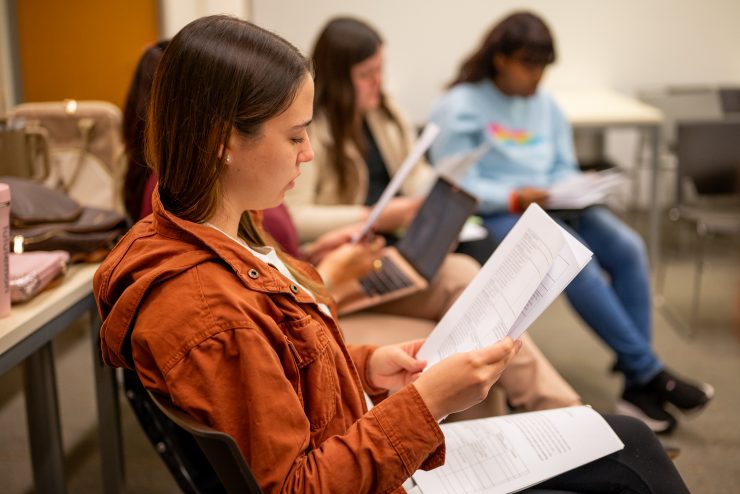 A psychology student reviews a document in class