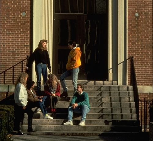 Adelphi students in the 90s standing in a doorway on campus.