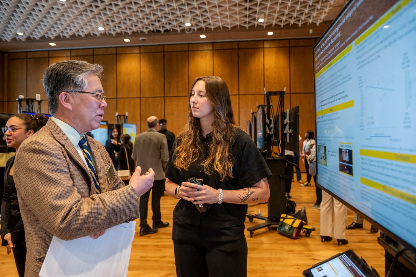 Vincent W. Wang, PhD, Dean College of Arts and Sciences, discusses neuroscience research with Chloe Ott, a lab manager in the Gordon F. Derner School of Psychology.
