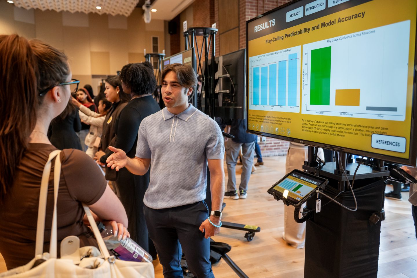 Senior computer science major Daniel Alvarez with his project, “Play-Calling Predictability and Model Accuracy”, showing how artificial intelligence might influence the game of football.