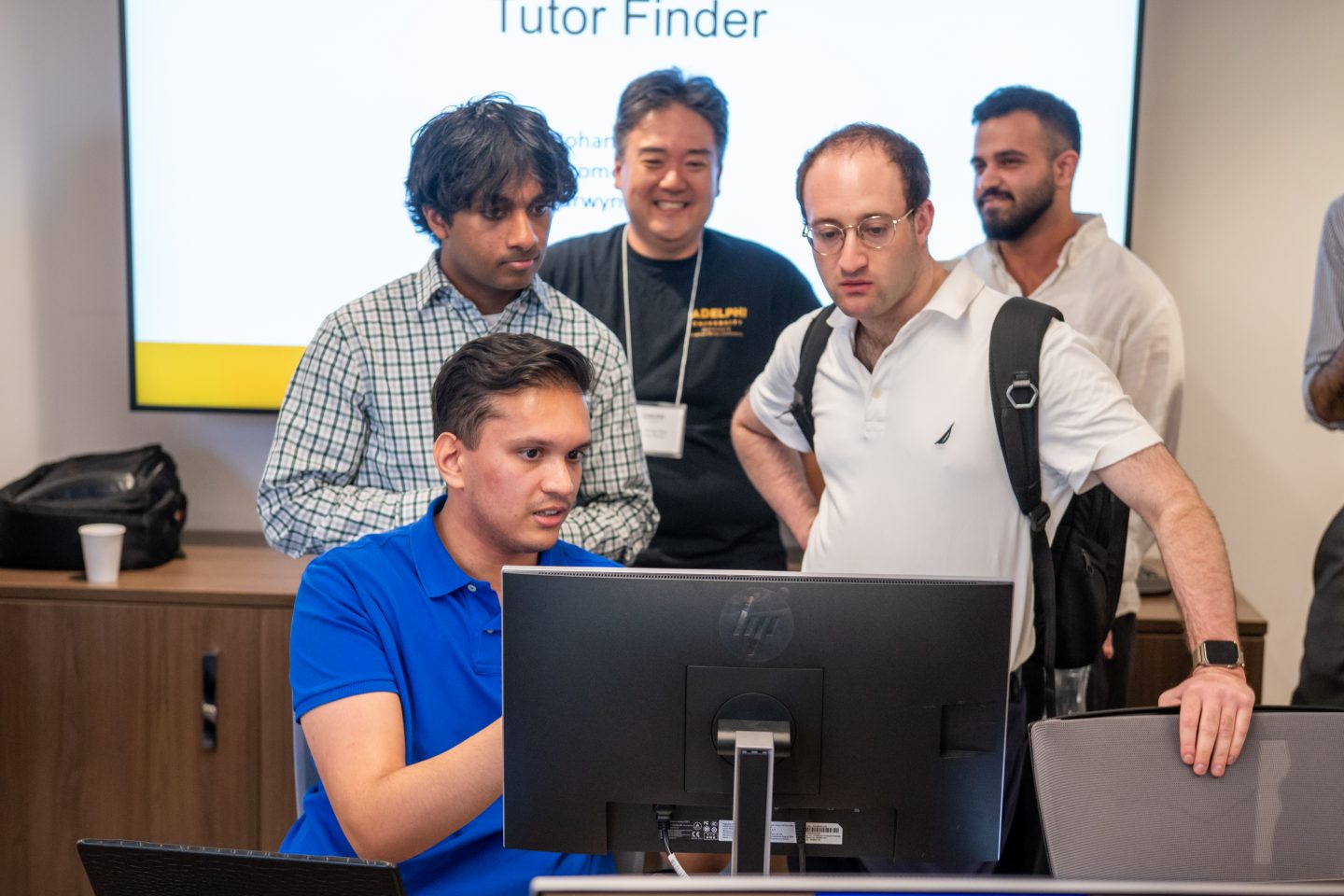 Students discuss computer science research at the Conference with assistant professor of mathematics and computer science Sung Kim, PhD (in black t-shirt).