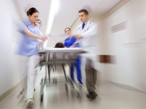 A blurred motion image of medical professionals pushing a stretcher in a hospital corridor