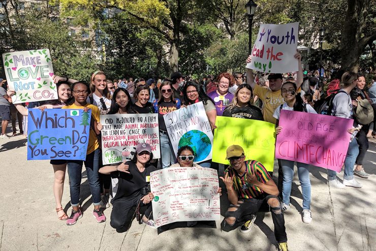 Adelphi students holding signs for climate justice at Adelphi's Garden City campus