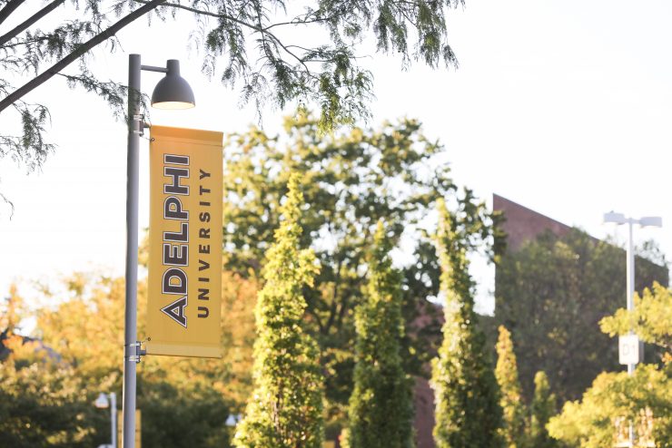 Adelphi University campus with banner showing logo