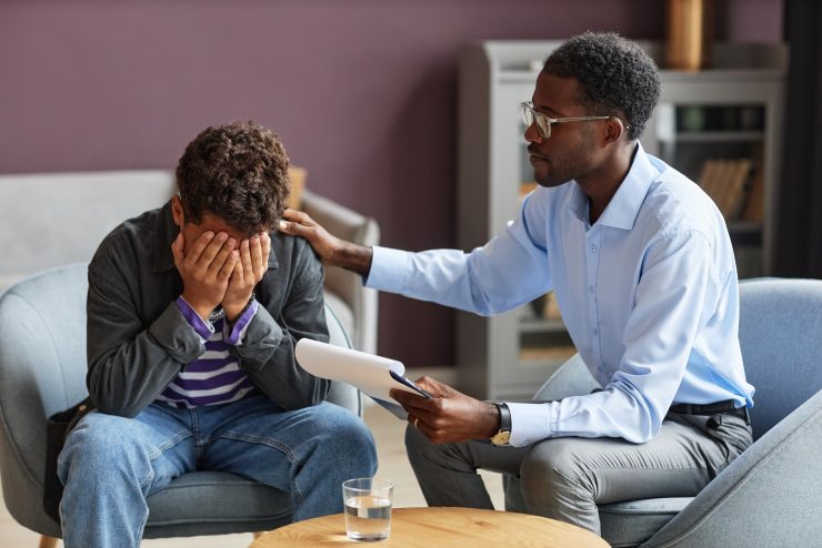 Boy in distress and male is comforting him