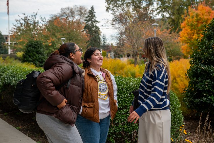 Fall Student Life - Adelphi students talk outside as the leaves change color.