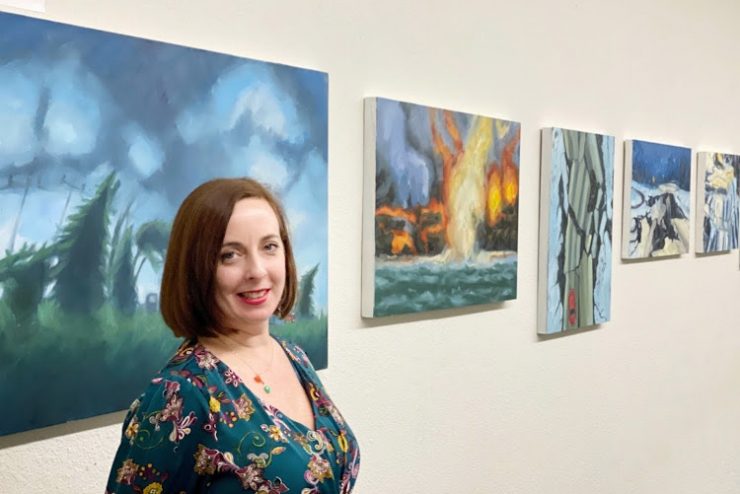 Kellyann Monaghan poses near her paintings