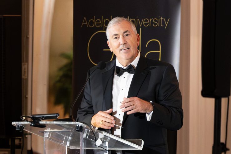 Michael Balboni speaking at a podium at the Adelphi University Gala.