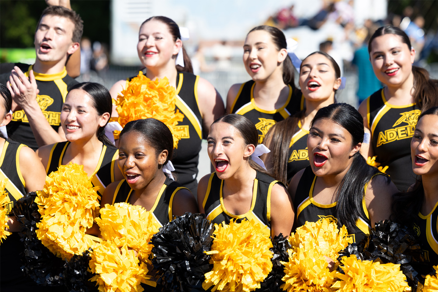 Two rows of Adelphi cheerleaders wave pom-poms, bringing the spirit.